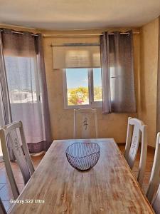 a wooden table with chairs and a bowl on top at APT Copacabana-Es Pujols playa in Es Pujols