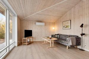 a living room with a couch and a tv at 0186-Romo-Egedesminde-3 in Høm