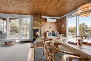 a dining room with a table and chairs and a fireplace at 0186-Romo-Egedesminde-3 in Høm