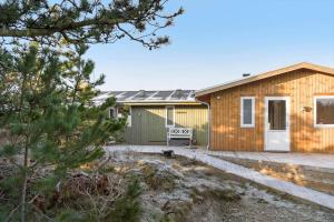 a house with a wooden facade and a deck at 0186-Romo-Egedesminde-3 in Høm