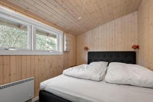 a bedroom with a bed in a room with two windows at 0186-Romo-Egedesminde-3 in Høm