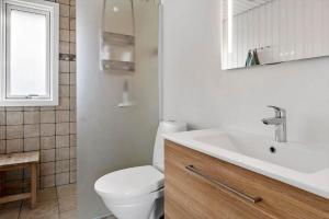 a bathroom with a white toilet and a sink at 0186-Romo-Egedesminde-3 in Høm +28 photos