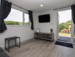 a living room with white walls and large windows at The Cabin - Private Car Park with CCTV - Fast WiFi - Peaceful Retreat with Views for Business or Couples in Oldbury