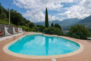 a large swimming pool with mountains in the background at NIC Lake House in Sulzano