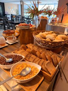 a buffet of bread and other food on a table at Reserva Praia Hotel in Balneário Camboriú
