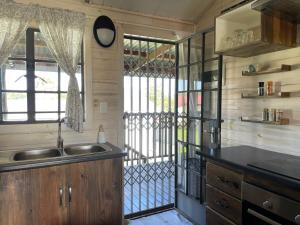 a kitchen with a sink and a window at Eindelik on de Lange in Graskop