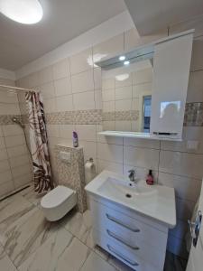 a bathroom with a sink and a toilet and a mirror at Sunce 5 in Vrbnik