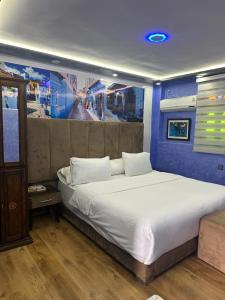 a bedroom with a large bed with a blue wall at Hotel Annasr in Chefchaouen