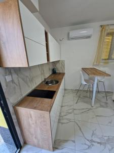 a kitchen with a sink and a table at Sunce 5 in Vrbnik