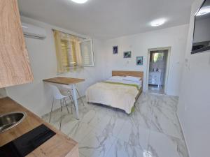 a bedroom with a bed and a table in it at Sunce 5 in Vrbnik