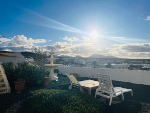two chairs and a table on a balcony with a view at Casa Vitto in Tinajo