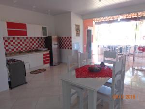 una cucina con un tavolo e sedie in una stanza di Jardim Atlantico a Paripueira Altre 13 foto