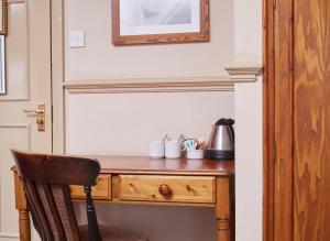 a wooden desk with a chair next to a door at Dog House by Chef & Brewer Collection in Abingdon