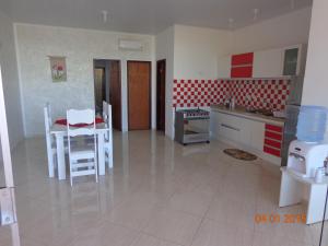 eine Küche mit einem weißen Tisch und Stühlen in einem Zimmer in der Unterkunft Jardim Atlantico in Paripueira