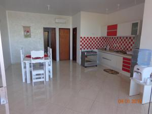 a kitchen with a white table and chairs in a room at Jardim Atlantico in Paripueira