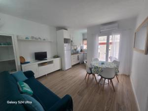 a living room with a blue couch and a table at APT Copacabana-Es Pujols playa in Es Pujols