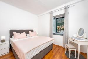 a bedroom with a bed and a desk and a window at Apartment Alen in Makarska