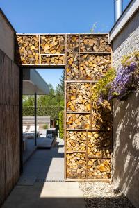 a stack of fire wood is on the side of a building at Vakantiewoning Relax Ohm in Zottegem