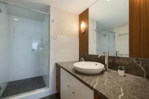 a bathroom with a sink and a glass shower at L17 Small Studio Suite 2 Beds Pool Spa in Gold Coast