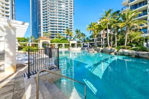 a swimming pool with palm trees and a tall building at L17 Small Studio Suite 2 Beds Pool Spa in Gold Coast +14 photos