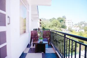 a balcony with a table and chairs and a window at Dhananjay home stay in Dharampur