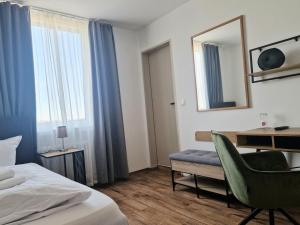 a hotel room with a bed and a desk and a mirror at Hotel Handelshof in Bünde
