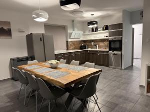 a kitchen with a wooden table and some chairs at Villa 121 Várgesztes in Várgesztes