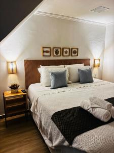 a bedroom with a large bed with two pillows at Suítes Viver Arraial do Cabo in Arraial do Cabo