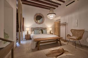 a bedroom with a bed and a chair and a mirror at Can Savella - Turismo de Interior in Palma de Mallorca