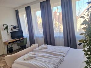 a room with two beds and a desk and windows at Hotel Handelshof in Bünde