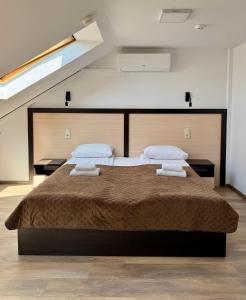 a bedroom with a large bed with two pillows at Hotel Koral in Chernivtsi