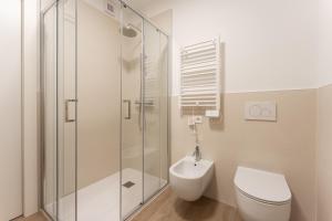 a bathroom with a toilet and a glass shower at Dama Apartments in San Vito di Leguzzano +10 photos