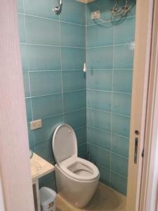 a bathroom with a toilet and a blue tiled wall at Studio Osnao Historic City Center in Cefalù +6 photos