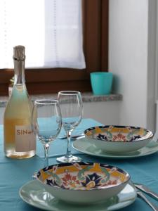 a table with two glasses and a bottle of wine at Casa Nausicaa in Pergine Valsugana