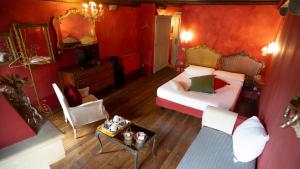 a bedroom with red walls and a bed and a table at Locanda Al Cappello in Udine