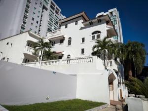 a white house with palm trees and tall buildings at Acacia Boutique Hotel in San Juan