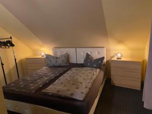 a bedroom with a large bed with two dressers at Apartment An der Büdnerei in Graal-Müritz