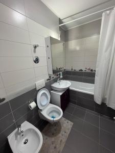 a bathroom with a toilet and a sink and a tub at Favorite Apartmet in Braşov +24 photos