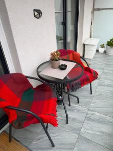 a table and two chairs sitting on a patio at Favorite Apartmet in Braşov