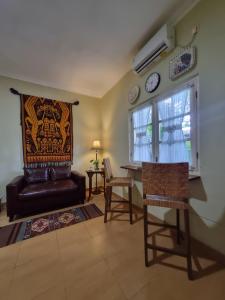 a living room with a couch and a table and a window at Comfy Room Yogyakarta BY Hamsa Putih in Yogyakarta