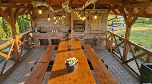 a patio with a long wooden table in a pavilion at Cichosza Miłomłyn in Miłomłyn