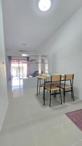 a dining room with a table and chairs at Joyful House Naiyang beach in Thalang