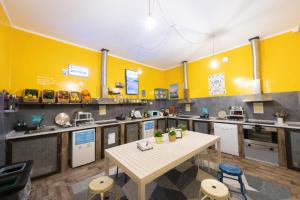 a kitchen with yellow walls and a table and chairs at Ostello Bello Napoli in Naples