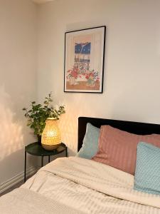 a bedroom with a bed and a vase on a table at Skolmästarevägen Åldersgräns 30 in Falun