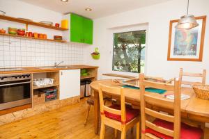 a kitchen with a wooden table and green cabinets at Canoe Welcome in Hattingen