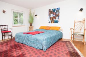 a bedroom with a bed and two chairs and a rug at Canoe Welcome in Hattingen
