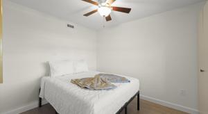 a bedroom with a bed with a ceiling fan at Mariner's Boathouse and Beach Resort by CoolVacay in Fort Myers Beach +32 photos