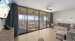 a living room with a couch and a balcony at Mariner's Boathouse and Beach Resort by CoolVacay in Fort Myers Beach