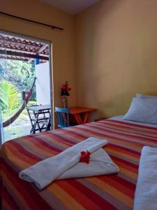 a bedroom with a bed with a towel on it at Pousada dos Mundos1 in Conde