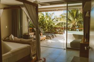 a bedroom with a bed and a balcony with a tub at Secret Garden Hideaway in Balcheil